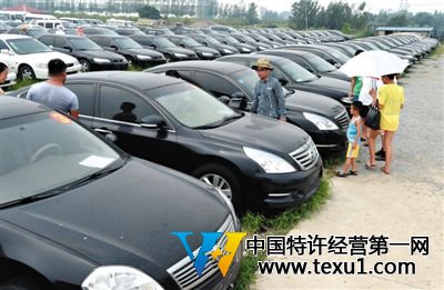 昨日,市民在山東棗莊一家拍賣公司場地上查看待拍賣公車。當日,棗莊市103輛公車公開拍賣。新華社記者